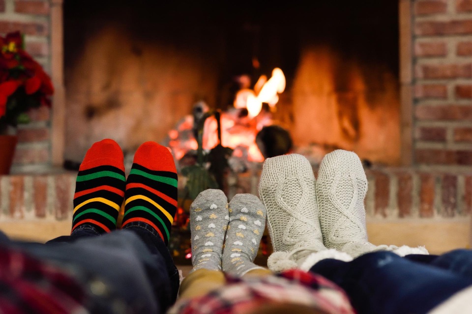 Eine Familie sitzt vor dem Ofen und wärmt sich